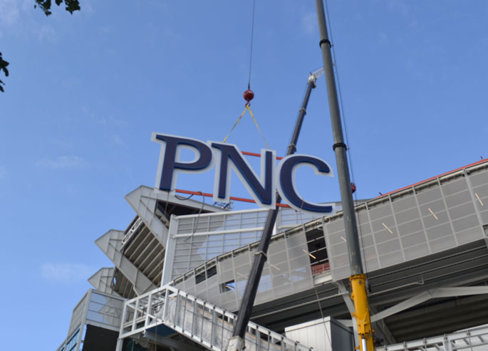 Installation of a PNC Bank sign at a stadium in Cleveland, Ohio
